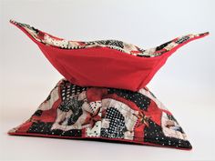 a red and black hat sitting on top of a white table