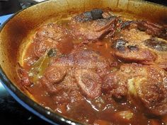 meat and vegetables cooking in a pan on the stove