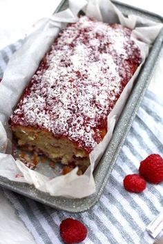 a cake in a pan with some raspberries on the side