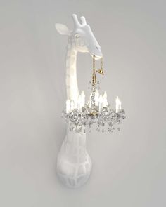 a giraffe is holding a chandelier in its mouth