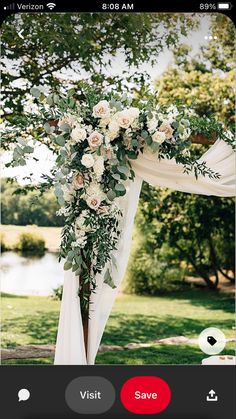 the wedding arch is decorated with white flowers and greenery, along with an instagram button