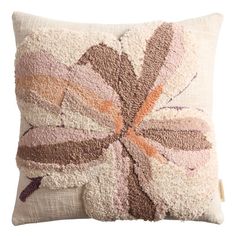 a decorative pillow with a flower design on the front and back of it, in neutral colors