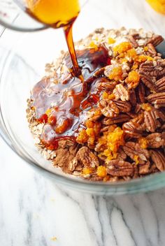 a bowl filled with oatmeal and caramel syrup being poured into it