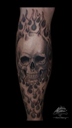 a man's leg with a skull and flames on it