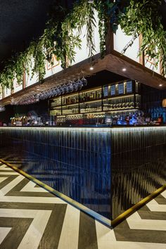 the bar is decorated with greenery and blue glass for an interesting effect to it's surroundings