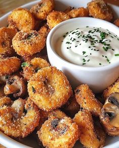 a white plate topped with fried mushrooms and dip