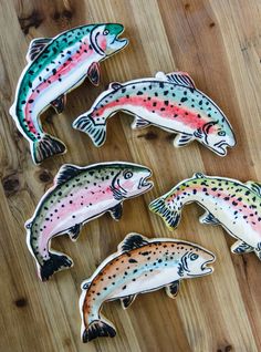 four fish shaped cookies sitting on top of a wooden table