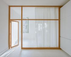 an empty room with white walls and curtains