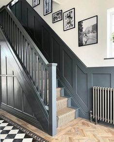 a staircase with pictures on the wall next to it and a radiator below