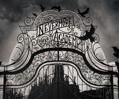 an iron gate with the words nevermore academy written on it and birds flying around