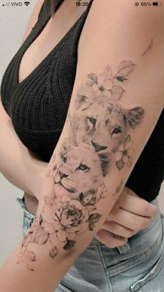 a woman's arm with a lion and flowers tattoo on the left side of her body