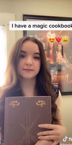 a girl holding up a book with the caption i have a magic cookbook