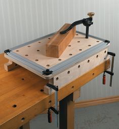 a workbench with a wooden block on it and tools attached to the table