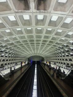 an empty subway station with people waiting for the train