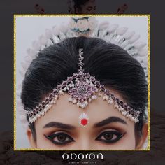 a woman wearing a tiara with pearls and jewels on her head in front of a white background