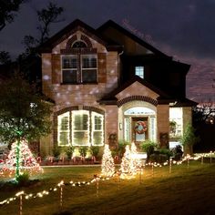 a house is decorated with christmas lights and trees