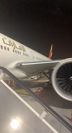 an airplane sitting on the tarmac at night with its landing gear down and it's engine out