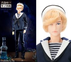 a doll with blonde hair and sailor outfit next to a miniature bottle filled with blue liquid