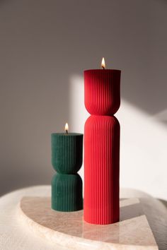 two red and green candles sitting on top of a table