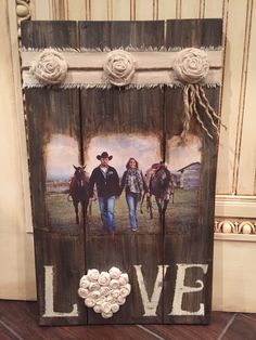 a wooden sign with two horses and the word love painted on it's side