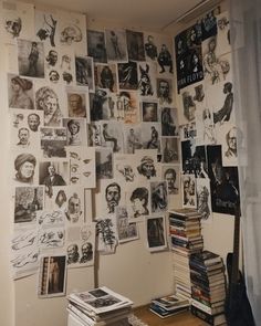 a room filled with books and pictures on the wall next to a window covered in curtains