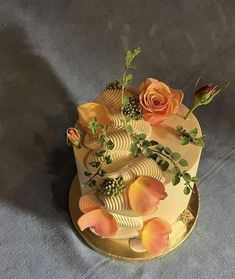 a cake decorated with flowers and leaves on a tableclothed surface, ready to be eaten