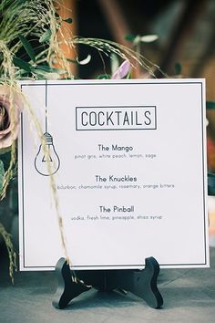 the menu for cocktails is displayed on an easel