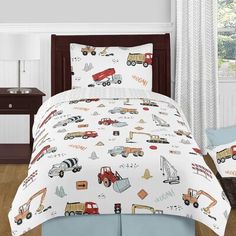 a child's bed with construction vehicles and trucks on the comforter, along with matching pillow shampoos