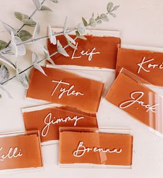 four pieces of paper with the names of different people on them and some flowers in the background