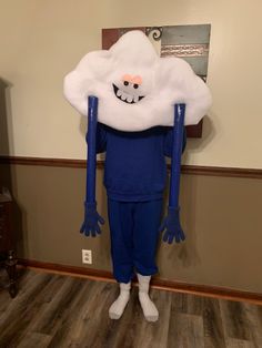 a man dressed as a cloud standing in front of a wall