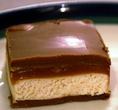 a close up of a piece of cake on a white plate with chocolate frosting