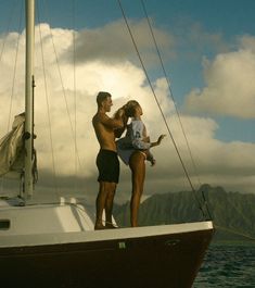 a man and woman standing on top of a boat