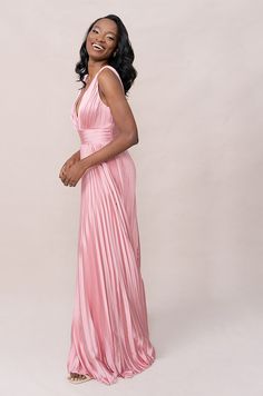 a woman in a pink dress posing for the camera