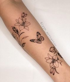 a woman's arm with flowers and butterflies on it