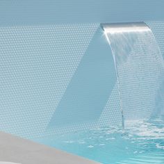 a man is standing in front of a swimming pool with a waterfall coming out of it