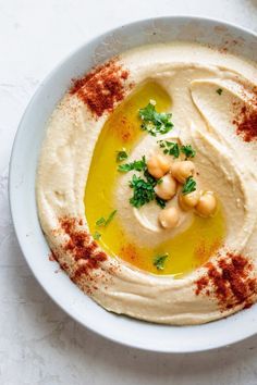 a white bowl filled with hummus and garnish