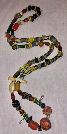 This is a fabulous 30 inch strand of assorted beads and amulets just filled with VERY collectible and somewhat rare antique beads. The tribal inspired 20-30 year old assemblage boasts a really great collection and is ready to wear or re-purpose. Beads are in good pre-owned condition with expected wear. The necklace has been strung for a while and will eventually need to be restrung. I do NOT guarantee any stringing, so bear that in mind. Antique and vintage necklaces like this are often on old s Traditional Multicolor Beaded Necklace For Healing, Vintage Beaded Necklace With Gemstone Beads For Festival, Vintage Beaded Necklaces With Gemstone Beads For Festivals, Vintage Gemstone Beaded Necklaces For Festivals, Amulet Style Necklace With Large Round Beads, Amulet Style Beaded Necklace With Large Oval Beads, Amulet Style Large Beads For Festivals, Gemstone Amulet Beads For Jewelry Making, Bohemian Large Beads For Healing