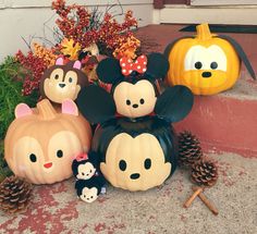 mickey mouse pumpkins and other halloween decorations on the front steps with their faces painted to look like disney characters