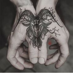 two hands holding each other with tattoos on their palms and one has a bird in the middle