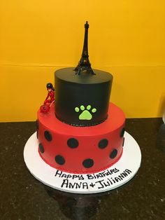 a red and black cake with the eiffel tower in the background