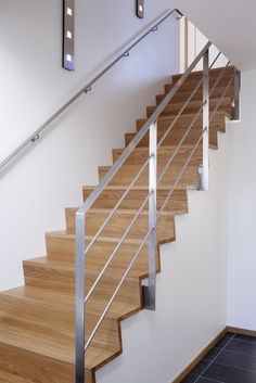 a wooden stair case with metal handrails