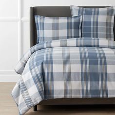 a blue and white plaid comforter set on a bed