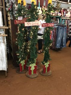 two christmas trees with presents on them in a store