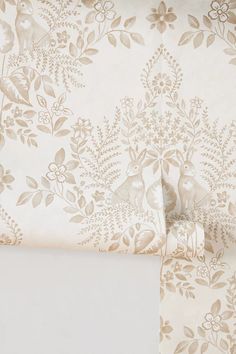 the wall paper is white and has gold flowers on it, along with two matching sheets