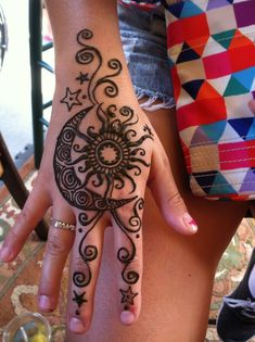 a woman's hand with henna tattoos on it