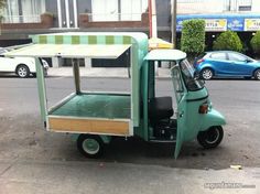 a small green truck parked in front of a building