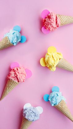 four ice cream cones with mickey mouse ears on them, all decorated in different colors