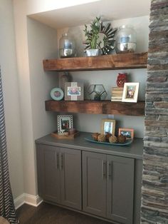 some shelves with pictures and vases on them in the corner of a living room