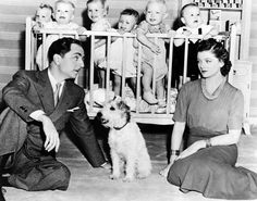 an old black and white photo of a family with their baby's in a crib