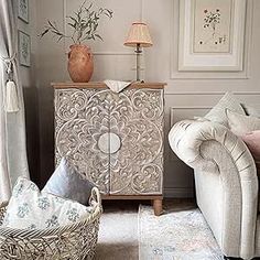 a living room with two chairs and a cabinet in the corner next to a window